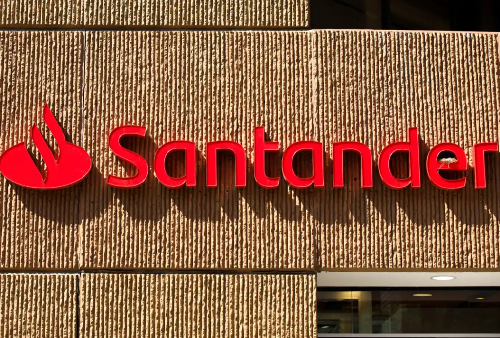 Logo do Santander em fachada de agência bancária, instituição financeira que oferece bolsas de estudo e cursos gratuitos em parceria com a AWS.